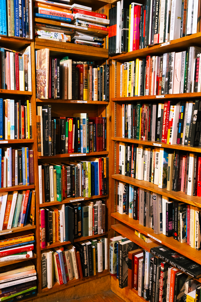 A vibrant library corner packed with diverse books on wooden shelves.