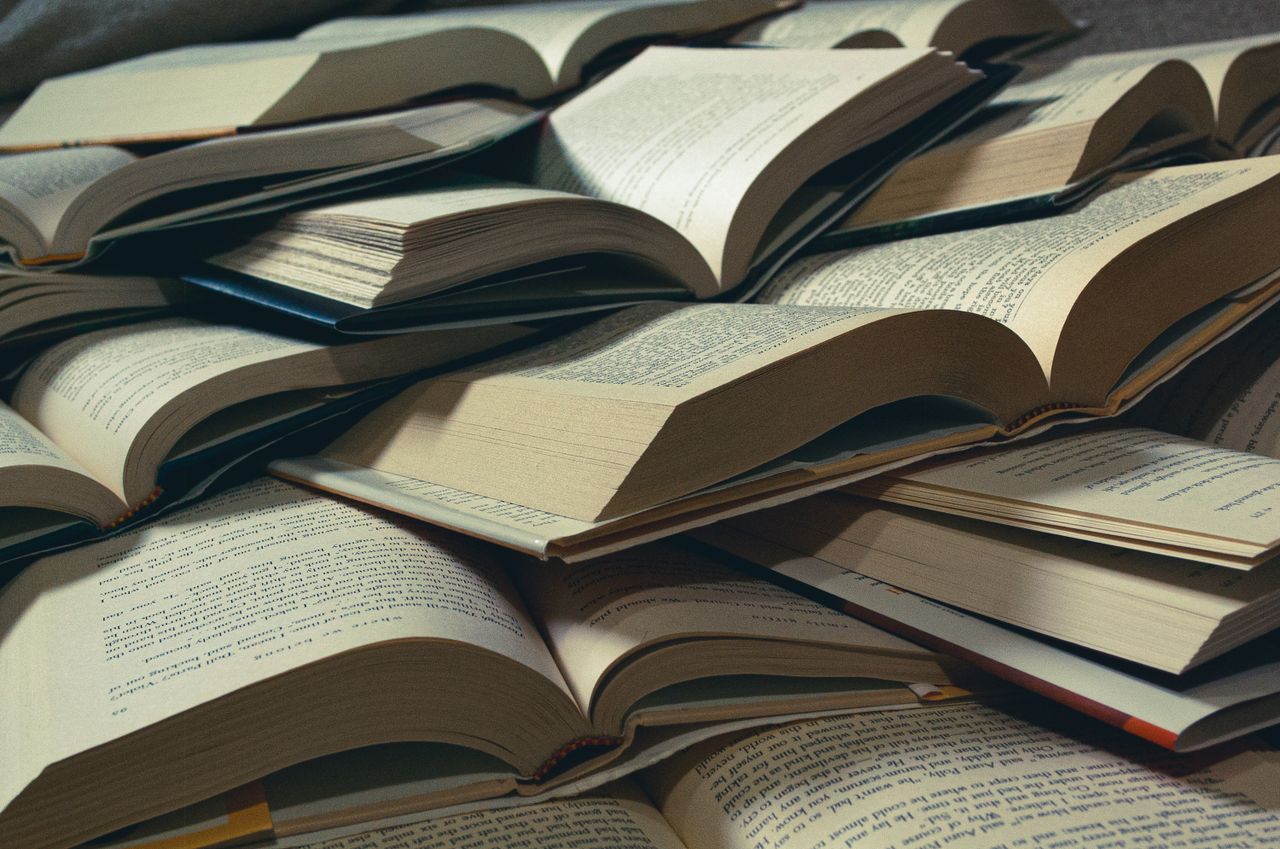 A close-up view of a pile of open books, perfect for bookworms and study sessions.
